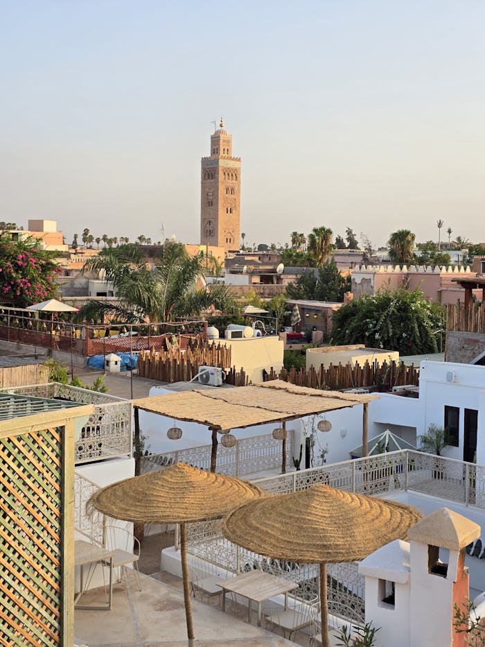 Scenic view of Marrakech rooftops and the iconic Koutoubia Mosque at sunset.